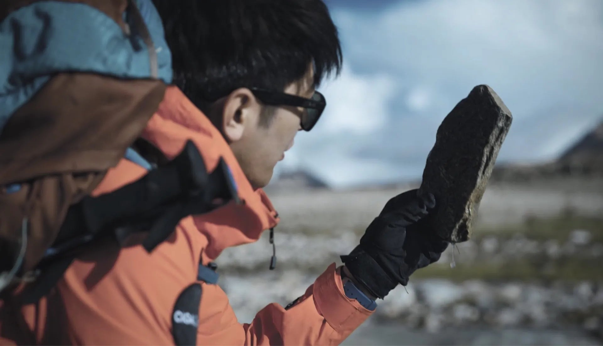 Integrante da equipe CIGA design segurando um bloco de rocha do Everest coletado ao pé da montanha